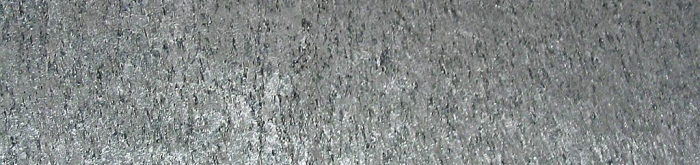 Křemen v relativně neutrální olověné stříbrné barvě s jemnějším 3D reliéfem a jednosměrným žíháním